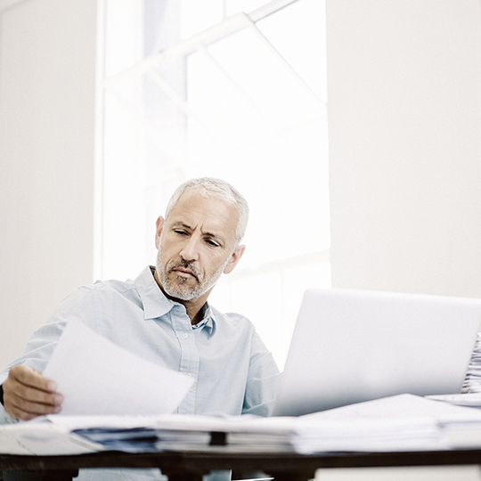 man looking into a paper