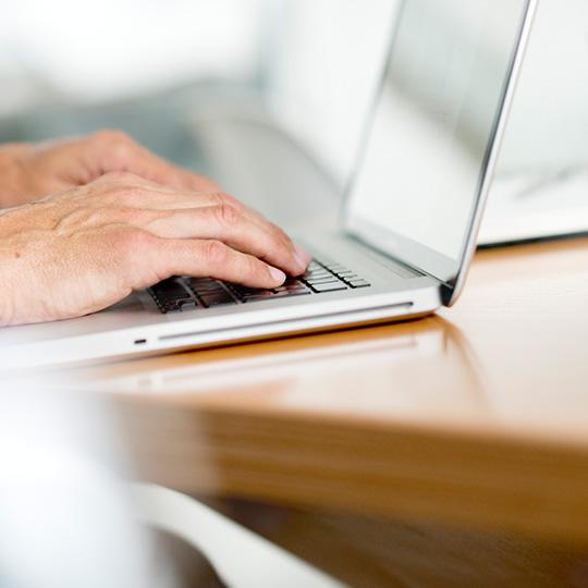Highest standards in data security close up of hands typing on a laptop