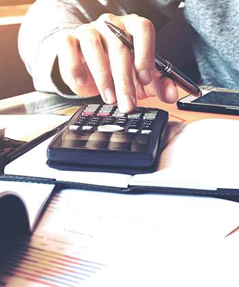 Audit and assure compliance close up of working on a calculator